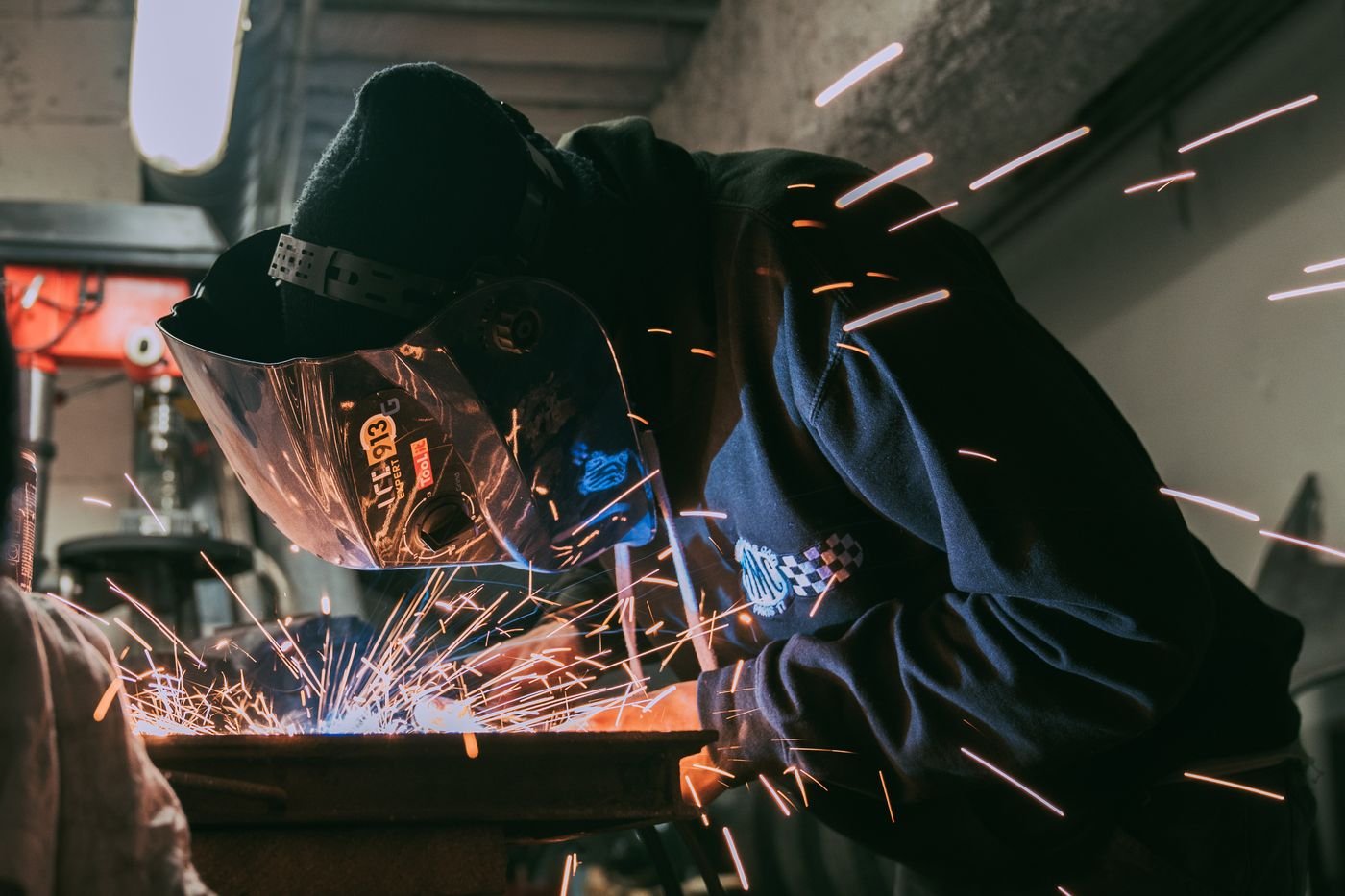 Welder working with sparks in an industrial workshop